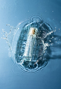 蓝色透明水珠摄影照片_水面上的化妆品瓶子