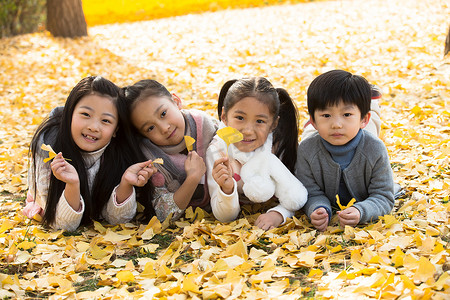 银杏叶秋摄影照片_可爱的男孩女孩在户外玩耍