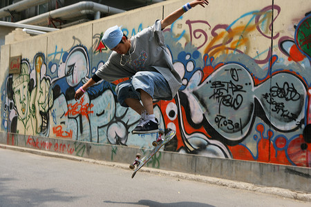 滑板男孩摄影照片_男青年在798艺术区玩滑板