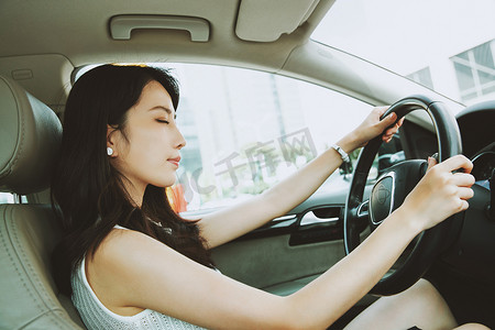 美女摄影照片_疲倦的青年女人开车