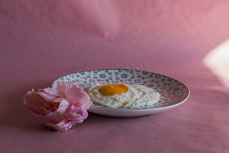 Homemade meal, Organic tasty cooked eggs for healthy breakfast on pink background, fancy ceramic plates, and flowers in a vintage artistic composition. Simple food composition.