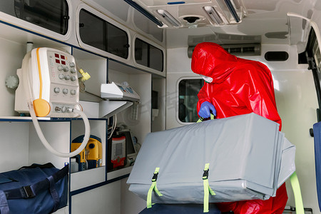戴口罩的男性辅助医务人员在大流行病期间帮助救护车上的呼吸机病人
