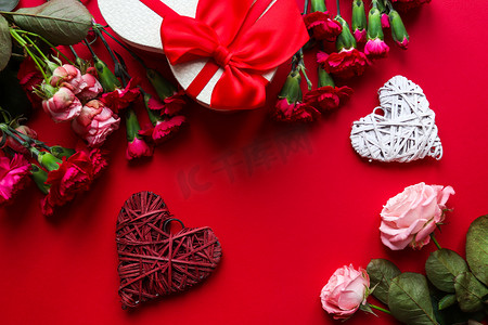 美丽的情人节贺卡。装饰心形，礼盒心形，红色背景的花朵与复制空间紧密相连。俯瞰，平铺