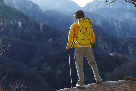 青年登山者站在山顶俯瞰