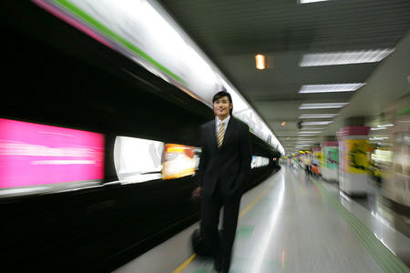 商务行走摄影照片_上海地铁站台一位男商务人士商务旅行