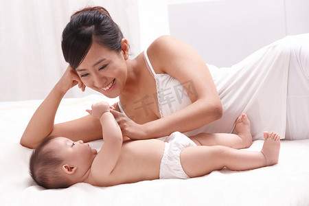 母亲和婴儿面对面躺在床上