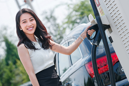 从充电桩取充电枪的漂亮青年女人