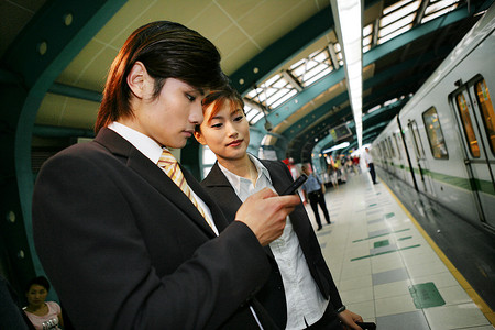 上海城铁站台两位商务人士使用手机