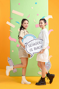 新同学新同学摄影照片_年轻女孩们拿着闹钟和新学期牌子