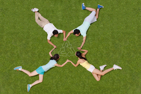 循环利用图片摄影照片_青年男女手牵手躺在草地上