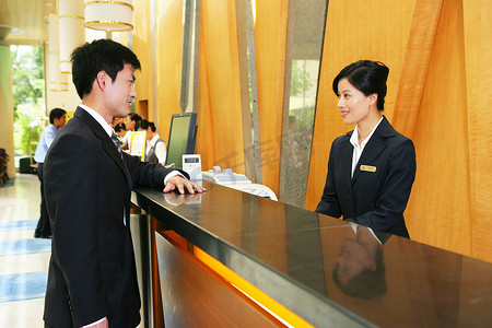 商务人士与酒店服务人员隔柜台交谈