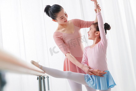 课外教育摄影照片_年轻舞蹈老师教小女孩跳舞