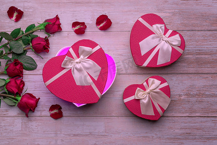敞开心扉盒情人的礼物在木制表面，玫瑰，花瓣。情人节2月14日或浪漫的夜晚邀请函、明信片、海报、装饰品