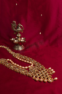 印度传统的青铜油灯，形状像一只鸟，背景是深红色的萨里。金属diya 。印度教徒的传统宗教仪式。Diwali.
