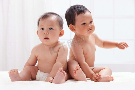 居室背景摄影照片_两个婴儿坐在室内床上