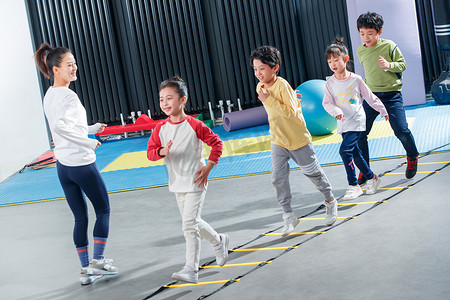 健康游戏摄影照片_儿童在教练的指导下进行体能训练