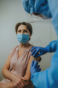 戴口罩的男医生摄影照片_整体防护医生及制造COVID-19疫苗手套