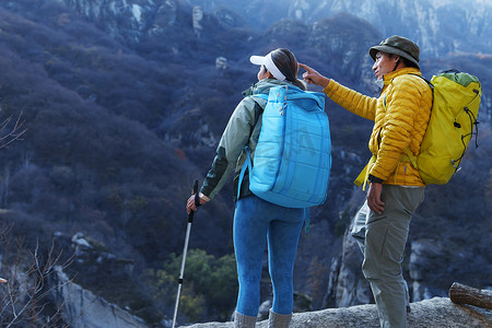 爬山山顶摄影照片_青年登山者伴侣站在山顶俯瞰