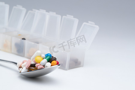 彩色多色摄影照片_匙上的多色药丸和药盒