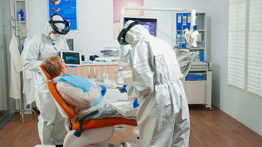 x显示屏摄影照片_用平板电脑复查X光防护设备的牙科医生