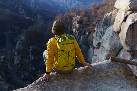 青年登山者坐在山顶俯瞰