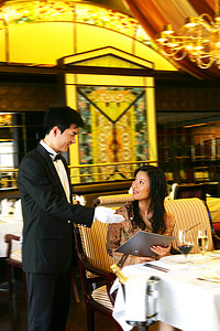 主题介绍摄影照片_酒店餐厅服务生向客人介绍菜单
