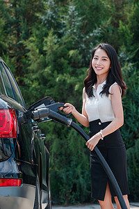 漂亮的青年女人给汽车充电