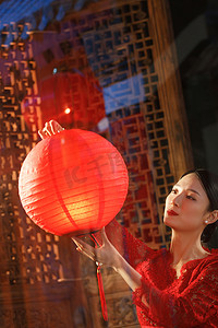 中国装饰元素摄影照片_年轻女人过年挂红灯笼