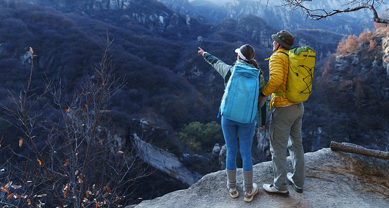 爬山山顶摄影照片_青年登山者伴侣站在山顶俯瞰