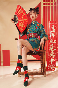 春节扇子扇子摄影照片_新年拿着扇子的年轻女人