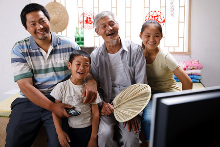 农民祖孙三代坐在家中看电视