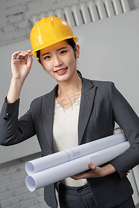 建筑师图片摄影照片_戴着安全帽的青年女工程师