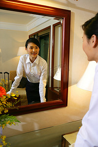 表情装饰摄影照片_年轻女士在酒店房间里对镜理妆准备出发