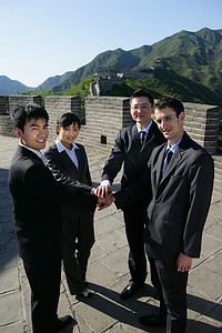 四位中外商务人士在长城上握手