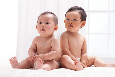 居室背景摄影照片_两个婴儿坐在室内床上