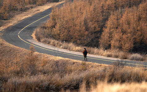 偏远的摄影照片_年轻女子户外徒步旅行的背影