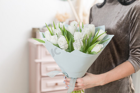 郁金香花摄影照片_美丽的豪华花束白色郁金香花在妇女手里。花店种花的工作.