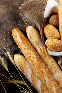 Baguettes 。面包放在褐色的木制桌子上.自制的小面包。法国面包特写。带有版权空间的顶级视图