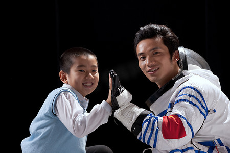 中国航天背景摄影照片_小男孩和宇航员手牵手