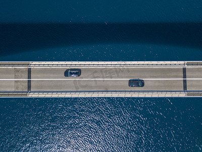 鸟瞰岛的桥梁, 克罗地亚, 道路。悬崖俯瞰大海。从上面看到的汽车过桥