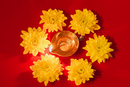 Diwali印第安灯节。地亚油灯和红色背景的黄色花朵。传统印度教庆祝活动。复制空间.