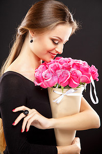 Close-up portrait of beautiful young woman with luxury jewelry and perfect make up holding bouquet. Fashion beauty portrait