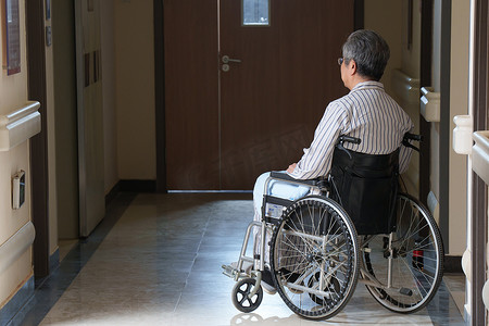 悲哀摄影照片_走廊内坐在轮椅上的老人