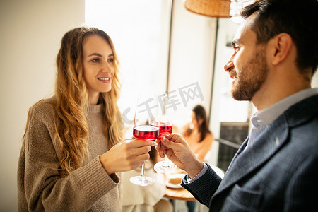 在咖啡馆吃早午餐喝红酒的年轻漂亮夫妇的剪影