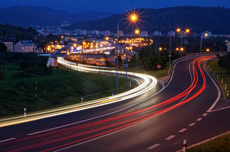 The city with street lighting in the valley at night, the light path headlights of cars