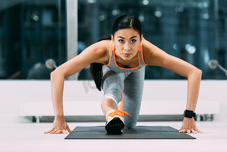运动亚洲女运动员伸展腿在健身垫在体育中心
