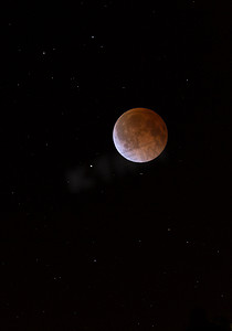 moving摄影照片_This is a photograph of the Lunar Eclipse Blood Moon moving out of its maximum stage at 3:00am Central Time. Background star field added from same sky location later.