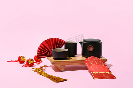 year摄影照片_Red envelope with tea and Chinese symbols on color background. New Year celebration