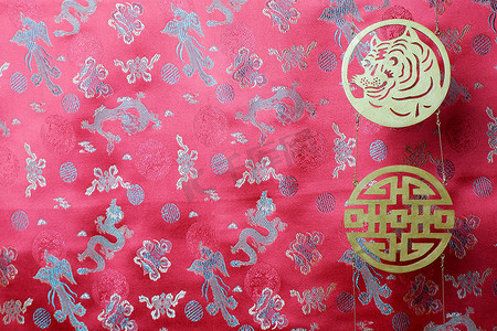 金虎和繁荣的象征在红色的面料上与中国的装饰鸟和龙。中国的虎年202
