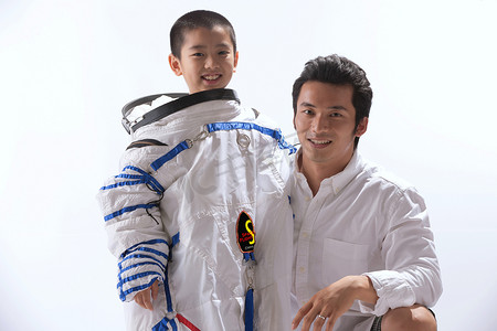 飞行员摄影照片_穿着宇航服的小男孩和宇航员在一起